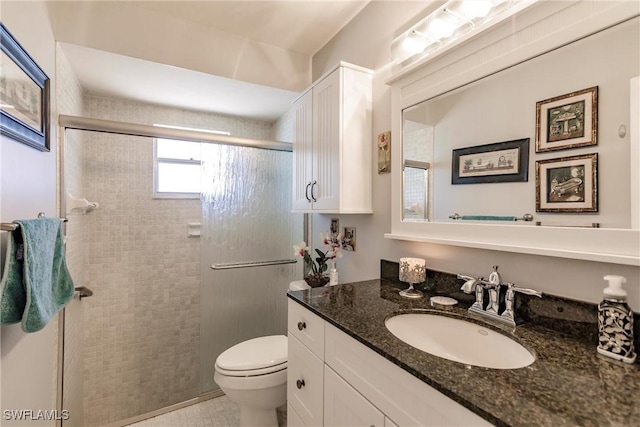 bathroom with vanity, a shower stall, and toilet