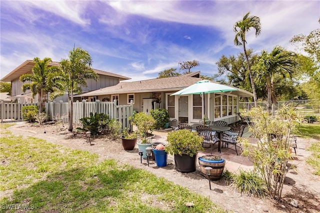 rear view of property with fence and a patio area