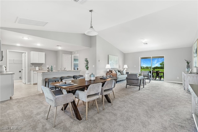 dining area featuring baseboards, light carpet, and lofted ceiling