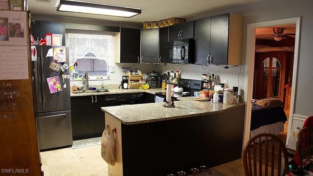 1280 Mcneill Rd, North Fort Myers, FL 33903 - kitchen featuring a peninsula, black appliances, dark cabinetry, and a ceiling fan