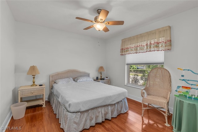 bedroom featuring ceiling fan, baseboards, and wood finished floors