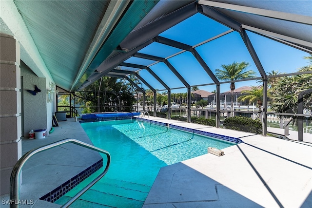 outdoor pool featuring an in ground hot tub, a lanai, and a patio area