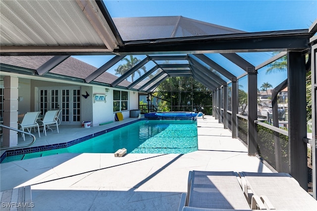 pool with a patio, french doors, an in ground hot tub, and a lanai