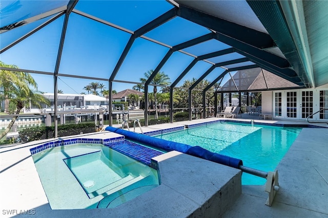 outdoor pool with french doors, a hot tub, glass enclosure, and a patio area