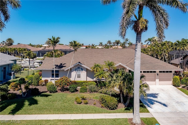 ranch-style house with stucco siding, a front lawn, roof with shingles, concrete driveway, and an attached garage