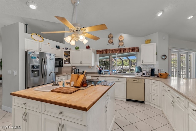 kitchen featuring dishwasher, stainless steel fridge, wooden counters, and a sink