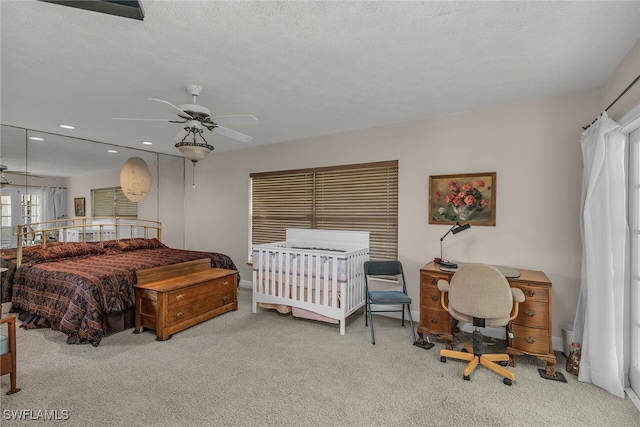 carpeted bedroom featuring recessed lighting and a textured ceiling