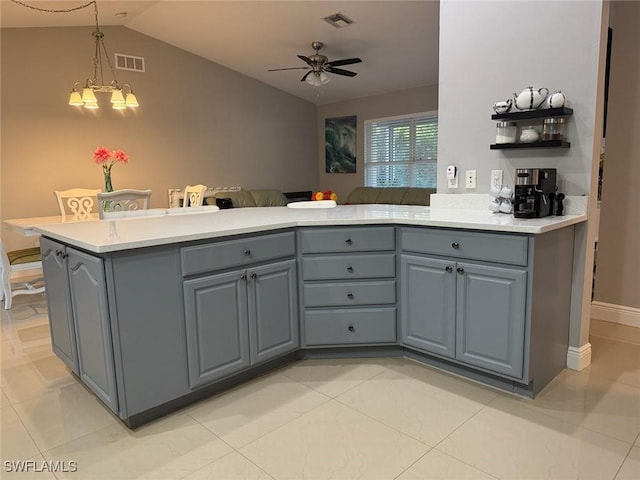 kitchen with gray cabinets, ceiling fan with notable chandelier, lofted ceiling, and visible vents