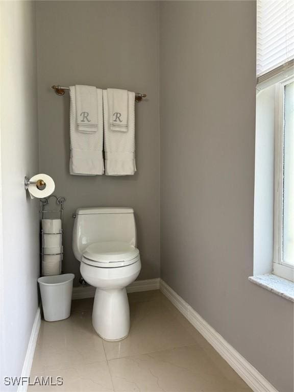 bathroom featuring baseboards, toilet, and tile patterned flooring
