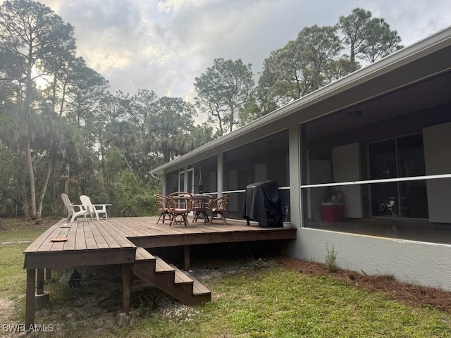 wooden deck featuring grilling area and a sunroom