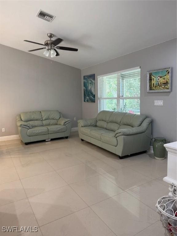 living room with light tile patterned floors, baseboards, visible vents, and a ceiling fan