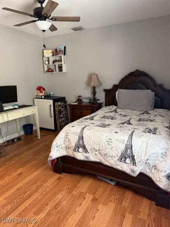 bedroom featuring visible vents, light wood-style floors, and a ceiling fan