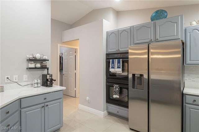 420 20th Ave NW, Naples, FL 34120 - kitchen with stainless steel fridge, gray cabinetry, lofted ceiling, light tile patterned floors, and baseboards