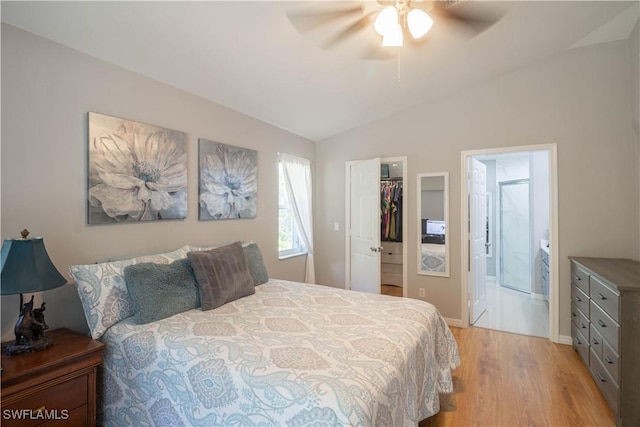 420 20th Ave NW, Naples, FL 34120 - bedroom with light wood-type flooring, vaulted ceiling, a walk in closet, a closet, and connected bathroom