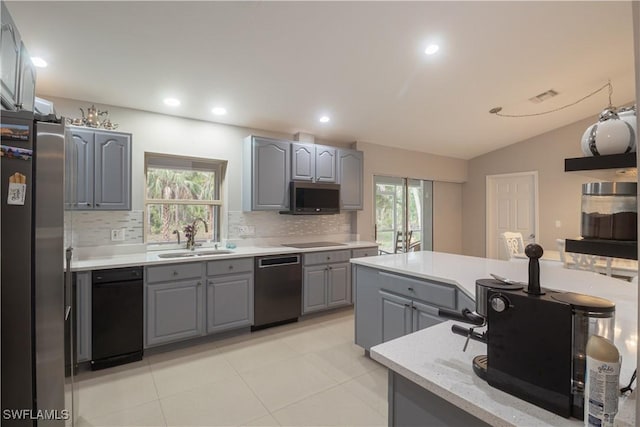 420 20th Ave NW, Naples, FL 34120 - kitchen featuring gray cabinetry, stainless steel appliances, a sink, backsplash, and lofted ceiling