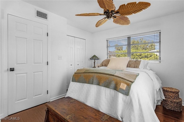 bedroom featuring ceiling fan, visible vents, a closet, and wood finished floors