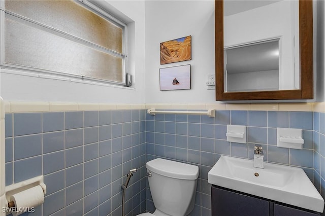 bathroom with a wainscoted wall, toilet, and vanity