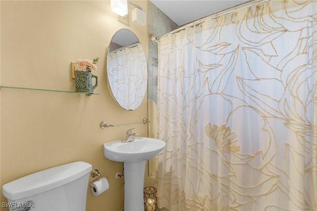 bathroom with curtained shower and toilet