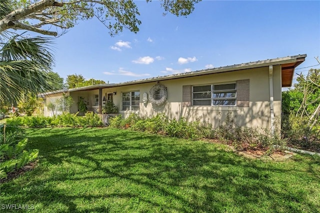 ranch-style house with a front lawn and stucco siding