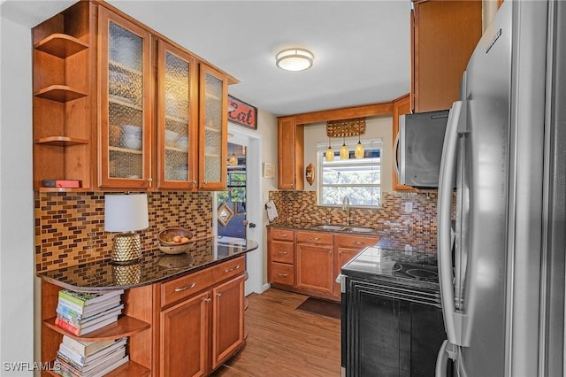 kitchen featuring backsplash, open shelves, freestanding refrigerator, black electric range oven, and a sink