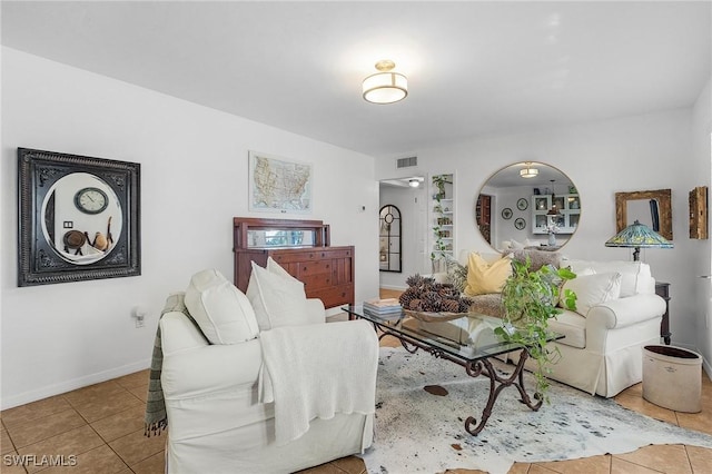 tiled living room with visible vents and baseboards