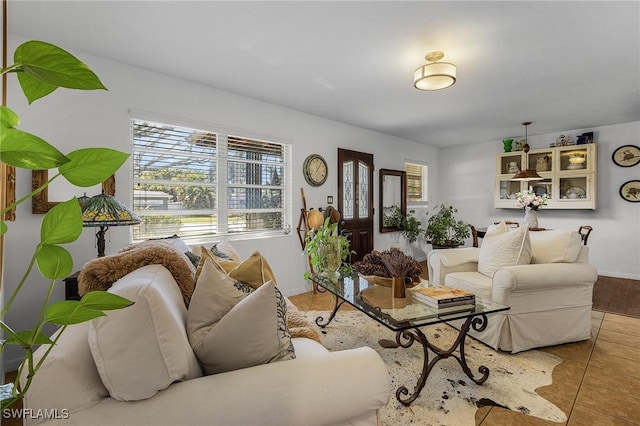 living room with baseboards and tile patterned flooring