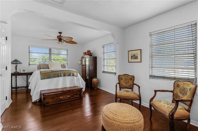 bedroom with multiple windows, a ceiling fan, baseboards, and wood-type flooring