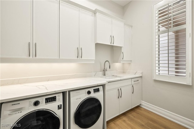 4831 Conover Ct, Fort Myers, FL 33908 - laundry room featuring washer and clothes dryer, a sink, baseboards, light wood-style floors, and cabinet space