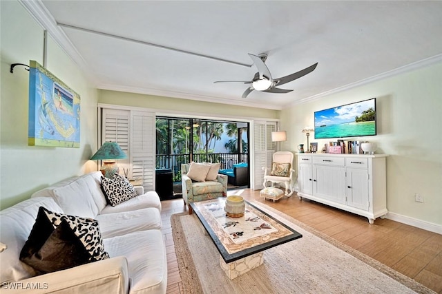 living room featuring baseboards, a ceiling fan, light wood-style flooring, and crown molding