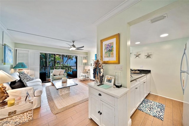 living area with light wood finished floors, visible vents, ornamental molding, recessed lighting, and a ceiling fan