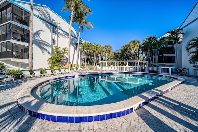 pool with a patio area and fence