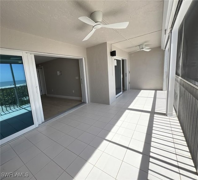 unfurnished sunroom featuring ceiling fan