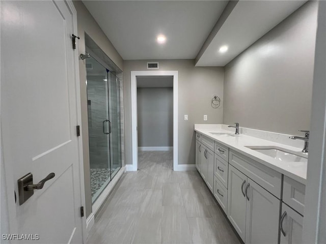 full bath with a sink, visible vents, baseboards, and a stall shower