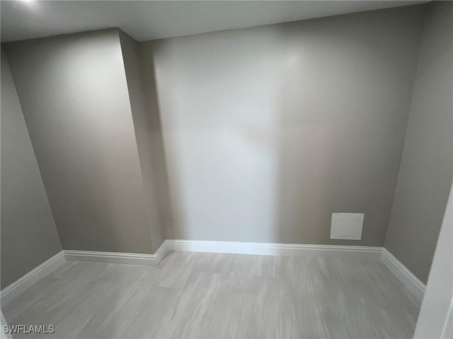 empty room featuring light wood-style floors and baseboards