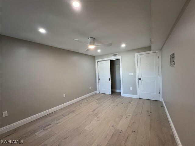 unfurnished bedroom featuring visible vents, baseboards, recessed lighting, light wood-style floors, and a closet