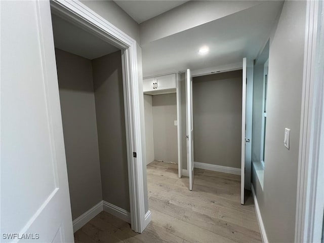 hallway with baseboards and light wood-style floors