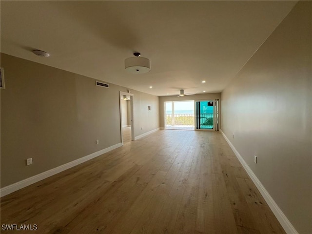 unfurnished room with visible vents, baseboards, a ceiling fan, and wood finished floors