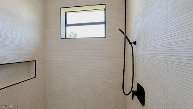 interior details featuring a tile shower