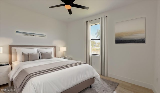 bedroom featuring baseboards, ceiling fan, and light wood finished floors