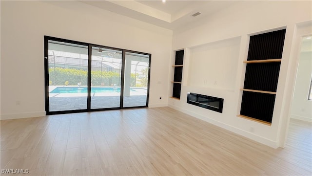 unfurnished living room with baseboards and light wood finished floors