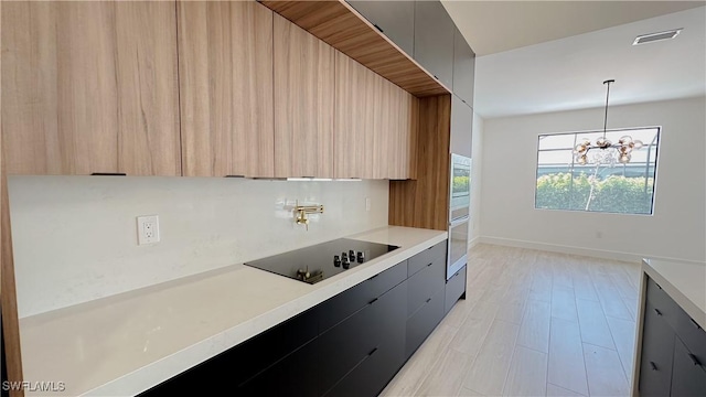 kitchen with visible vents, light countertops, appliances with stainless steel finishes, a notable chandelier, and modern cabinets