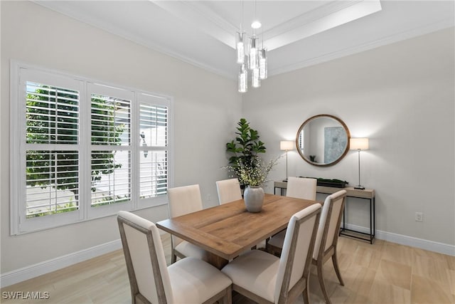 dining room featuring baseboards, a tray ceiling, ornamental molding, an inviting chandelier, and light wood-style floors