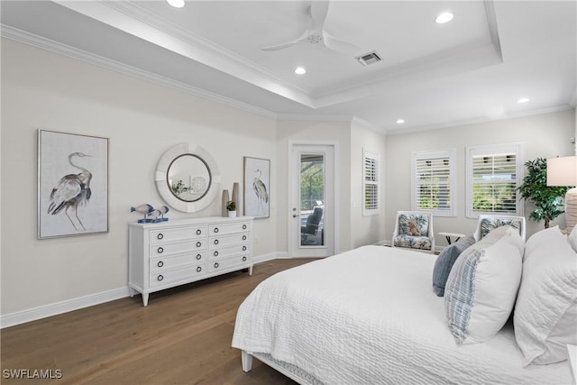 bedroom featuring wood finished floors, visible vents, a tray ceiling, ornamental molding, and access to exterior