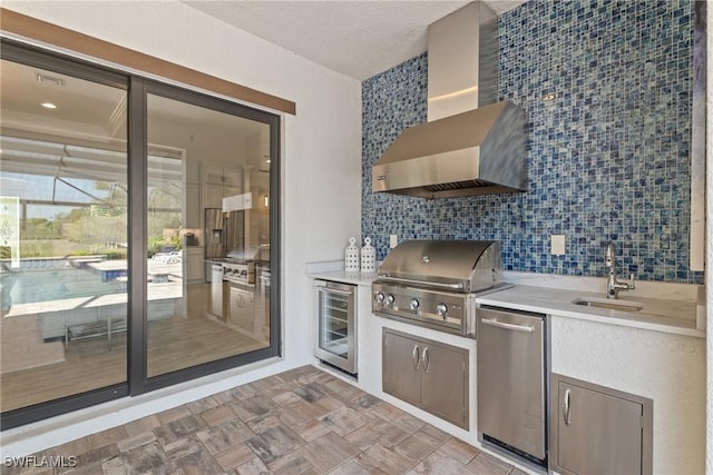 view of patio featuring wine cooler, grilling area, an outdoor kitchen, and a sink