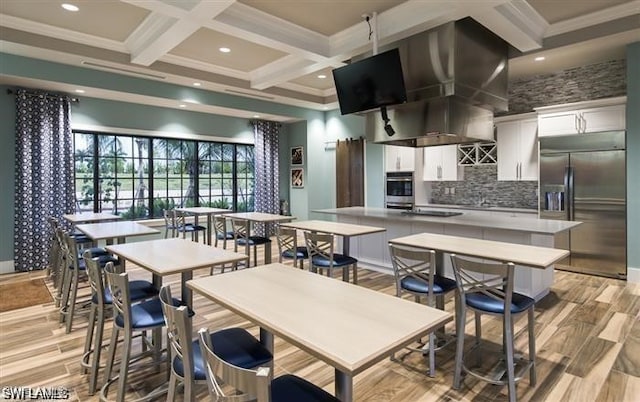 kitchen with coffered ceiling, stainless steel built in refrigerator, decorative backsplash, white cabinets, and a center island