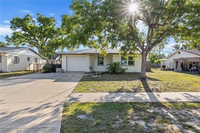 ranch-style home with an attached garage, a front lawn, fence, stucco siding, and driveway