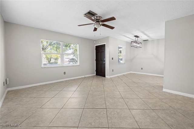 empty room featuring plenty of natural light, baseboards, and a ceiling fan