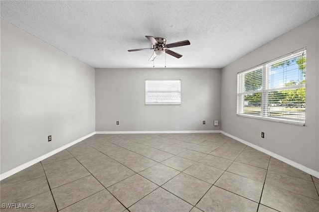 spare room with baseboards, a textured ceiling, light tile patterned flooring, and a ceiling fan