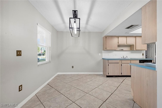 kitchen with visible vents, light brown cabinetry, light countertops, light tile patterned floors, and baseboards