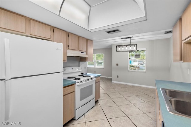 kitchen featuring white appliances, visible vents, under cabinet range hood, and a sink